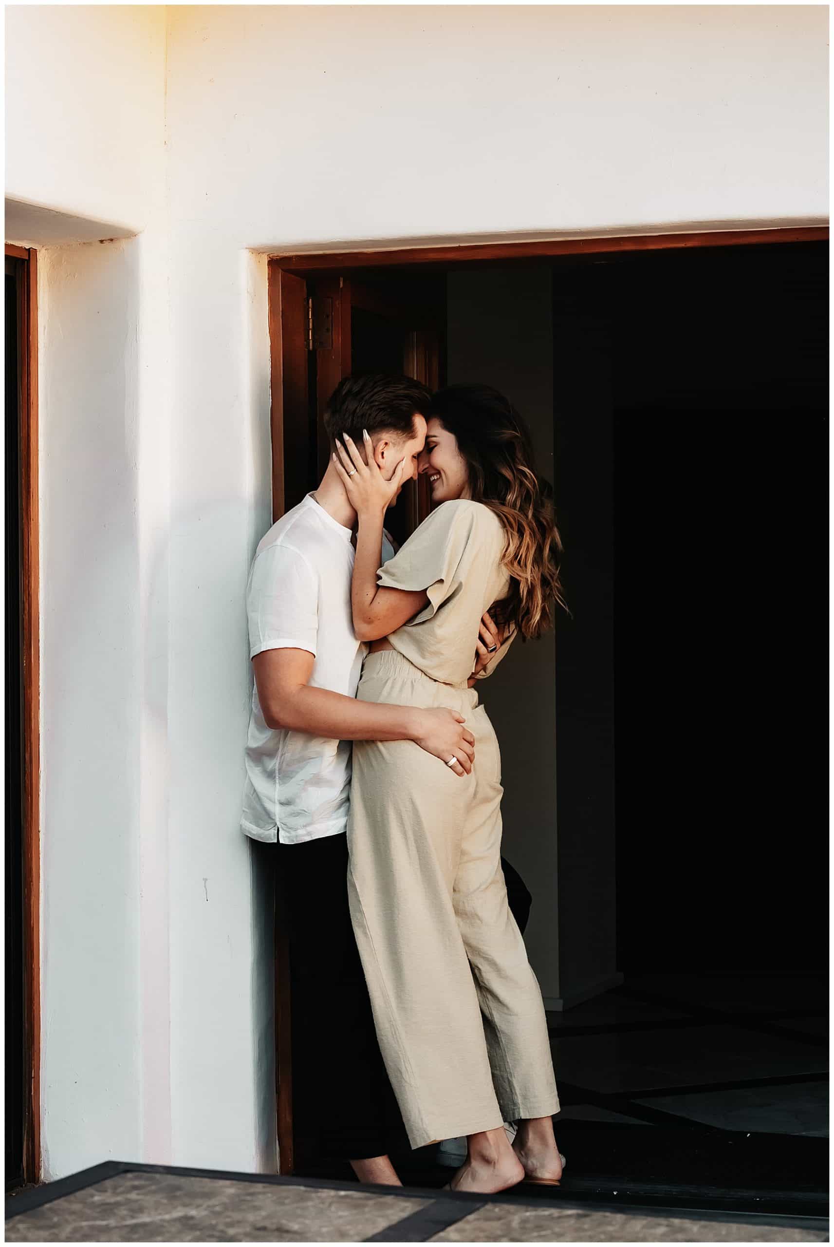 Couple-kissing-against-house-wall